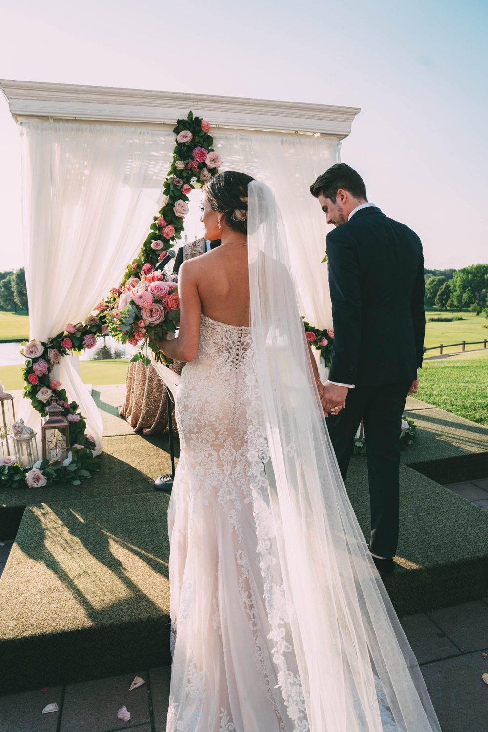 Adrienne's bride from behind with a cathedral veil at an altar